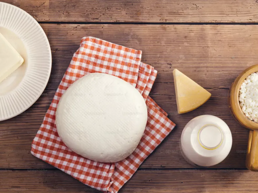 Formaggi freschi, ricotta e latte su tavolo di legno
